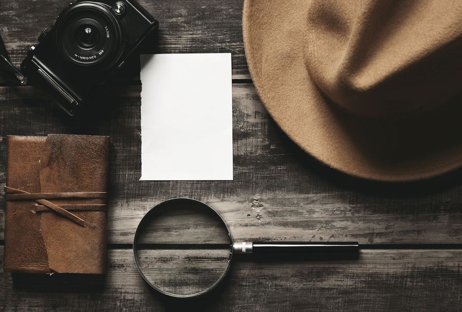 Outils du détective privé : carnet, appareil photo, loupe